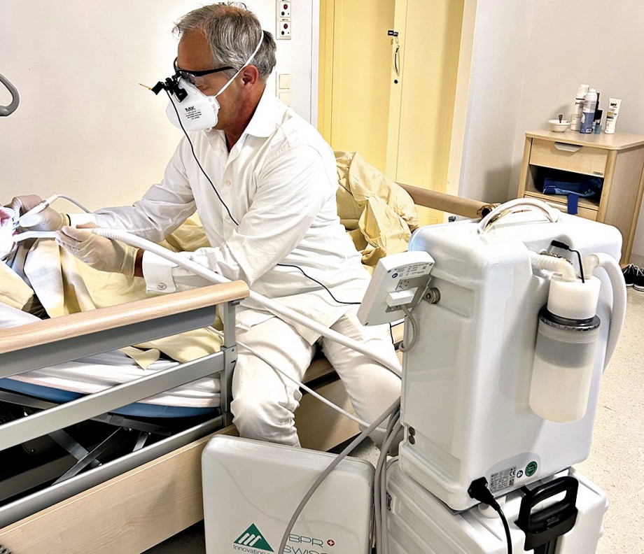 Dr. Ernst Weinmann behandelt eine bettlägerige Patientin mit mobiler Behandlungseinheit im Pflegeheim